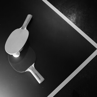 An elegant hand mirror lies on a dark surface. Its reflective design creates an interesting contrast. | © Stick Ford