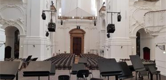 A magnificent church with high ceilings and ornate frescoes. Impressive organs can be seen on the walls. | © Katholische Hochschulgemeinde