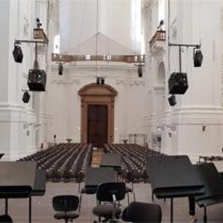A magnificent church with high ceilings and ornate frescoes. Impressive organs can be seen on the walls. | © Katholische Hochschulgemeinde