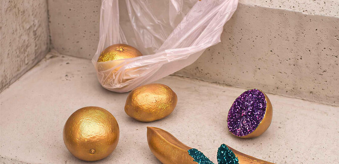 An unusual view of gold balls and a colorful banana scattered on a staircase. A transparent plastic bag is also lying on the steps. | ©  Schauspielhaus Salzburg