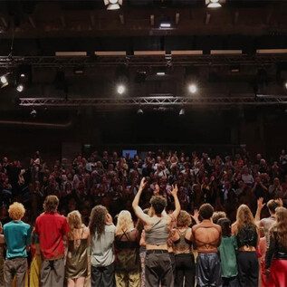 Eine große Menschenmenge steht auf der Bühne und applaudiert. Im Hintergrund sind Zuschauer zu sehen, die das Event verfolgen. | © www.sead.at