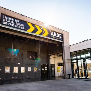 Ein modern gestaltetes Gebäude mit großem Eingang. Darüber steht der Schriftzug "ARGE - Das Haus für Veranstaltungen und Produktionen". | © www.hannelore-kirchner.com