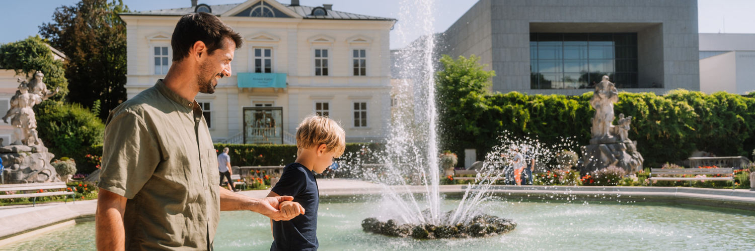 Picture of a father and his son next to the fountain in Mirabell Garden. | © Tourismus Salzburg Gmbh / M. Kohlmayr